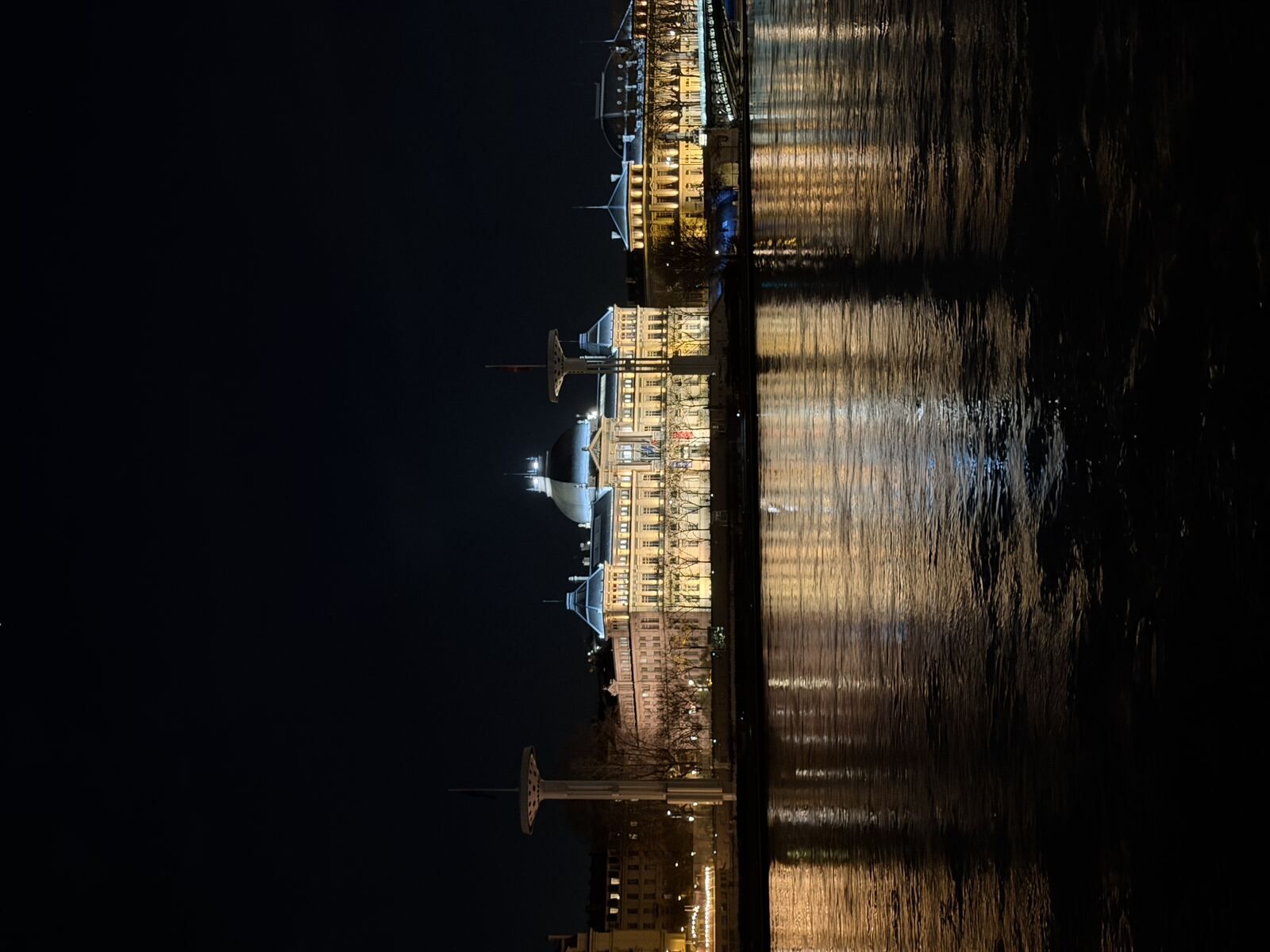 Le Palais de la Bourse de Lyon illuminé la nuit, vu depuis les quais de Saône